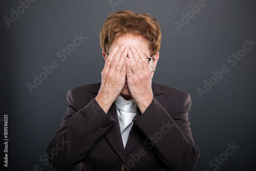 Business senior lady holding hand over eyes