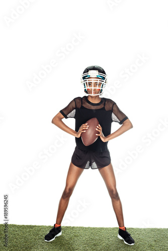 equiped female american football player standing on grass with ball isolated on white © LIGHTFIELD STUDIOS