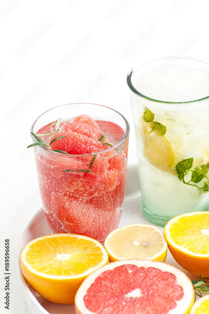 A glass of lemonade with grape-cucumber slices and lemon on a white background.. A glass of lemonade with grape-cucumber slices and lemon on a white background..