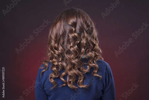 Принти на полотні head brown-haired woman with curly hair on a dark red background isolated rear v