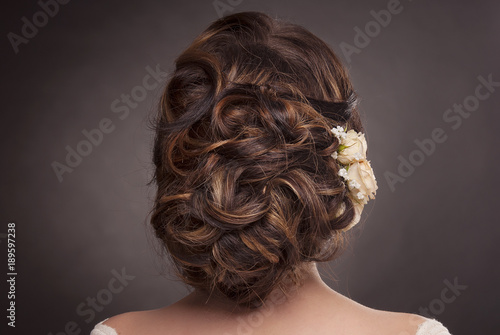 head of woman with hair in wedding bun on gray isolated background rear view of brown hair