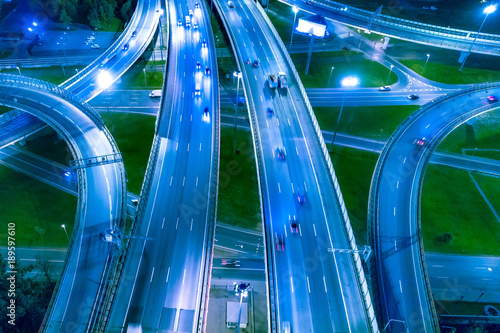 Car traffic. Night roads from a height. Decoupling highways. Automobile roads in the evening lighting.