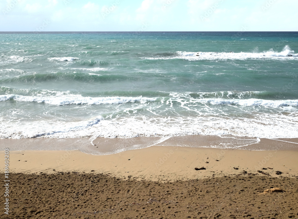 Landscape with sea surface with weaved small waves on sand beach on summer day