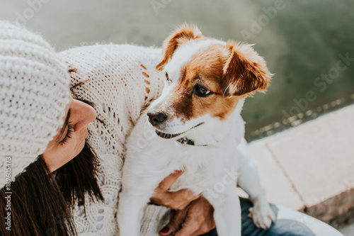 .Pretty young woman playing with her adorable dog Jack Rusell in a park surrounded by cactus and a small pond. Adorable sunny autumn day. Lifestyle. photo