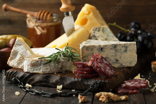 Assorted cheeses with grapes, nuts and rosemary