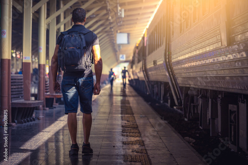 Young traveler walking with backpack on train station in thailand