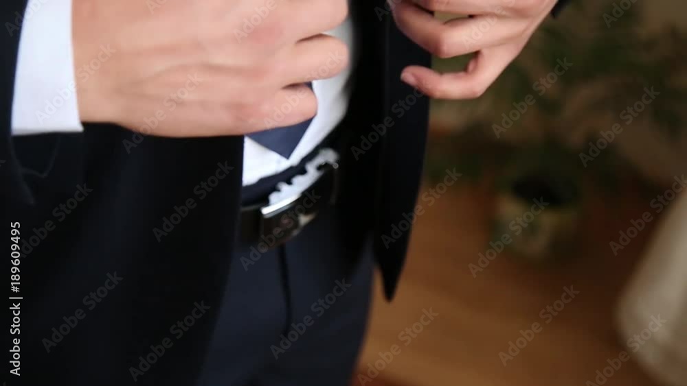 Successful man in the blue suit straightens his sleeves, close-up Successful man in the blue suit straightens his sleeves, close-up