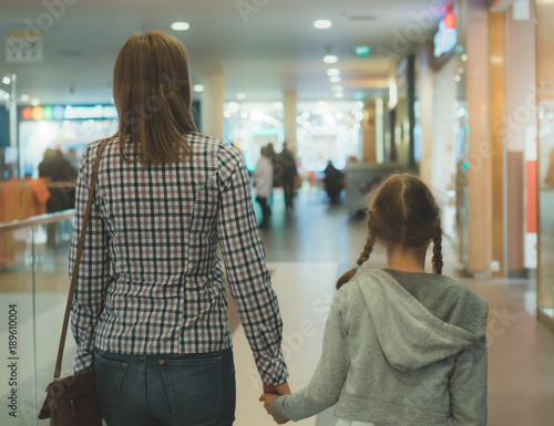 Mom and daughter walking in shopping mall.