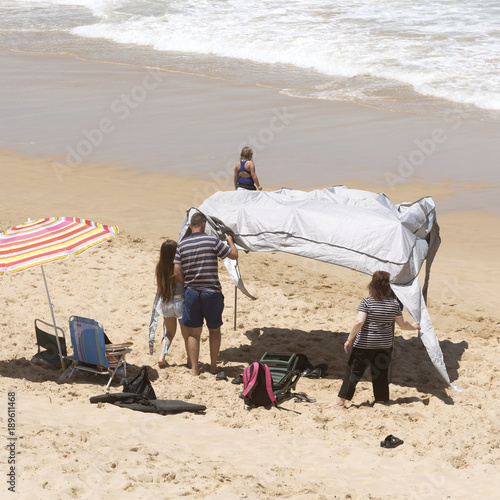 Glentana seaside resort on the Garden Route near George Western Cape, South Africa. December 2017. Holidaymakers erect a gazebo for shading the sun photo