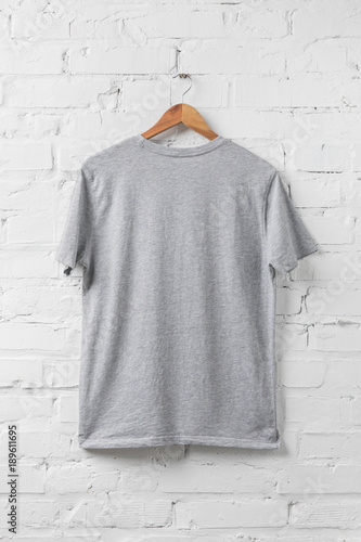 one grey shirt on hanger on white wall