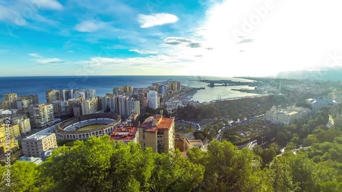 Panoramic aerial view of Malaga city, Costa del Sol, Andalusia, Spain. Cityscape of La Malagueta district with port and Toros de Ronda bullring. View from Gibralfaro castle. Time Lapse. 4K UltraHD