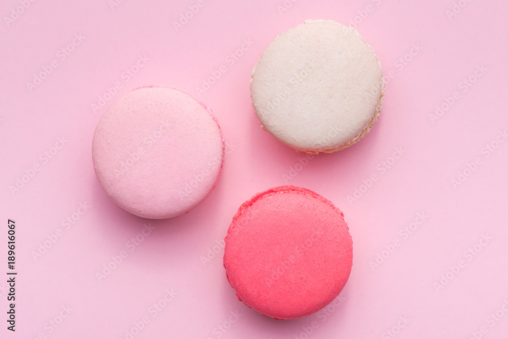 Top view of mini pink and white macaron on soft sweet pink paper background Top view of mini pink and white macaron on soft sweet pink paper background