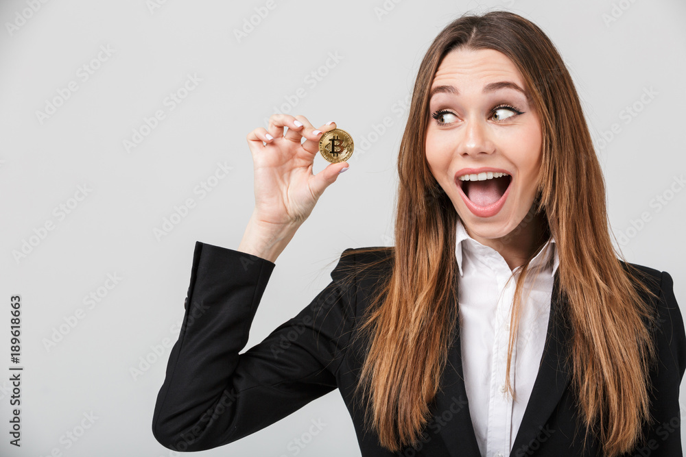 Photo of pretty businesswoman looking at golden bitcoin isolated Photo of pretty businesswoman looking at golden bitcoin isolated