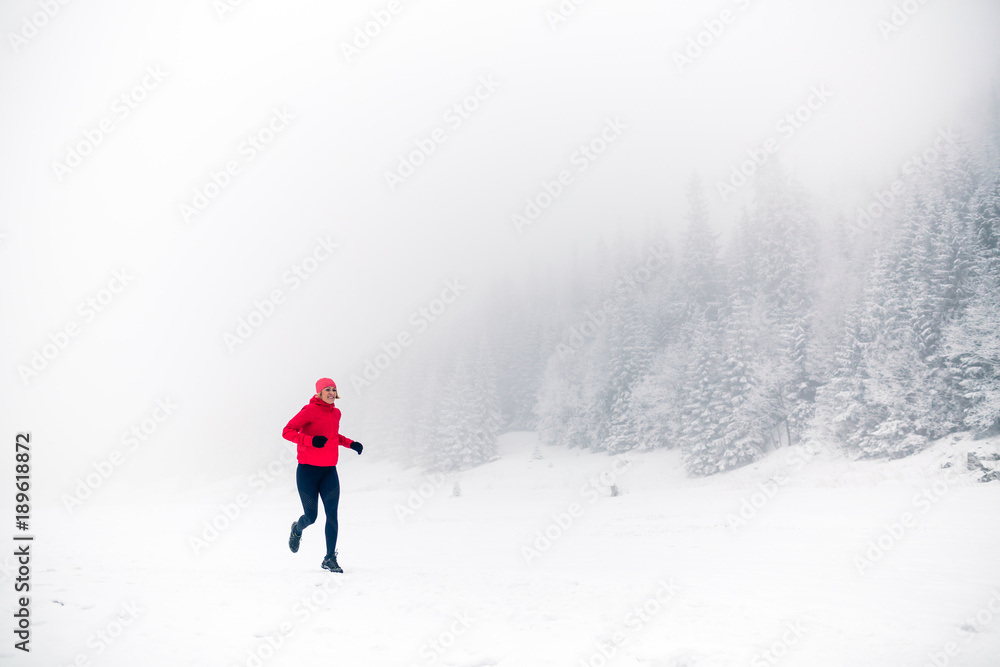 Trail running on snow in winter mountains