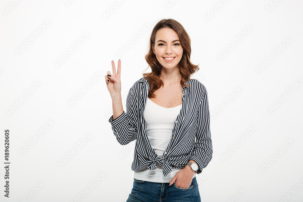 Portrait of a smiling casual girl showing ok gesture