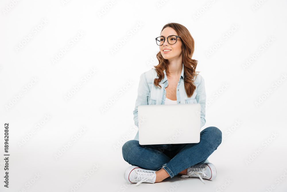 Fototapeta premium Portrait of a happy casual girl holding laptop computer