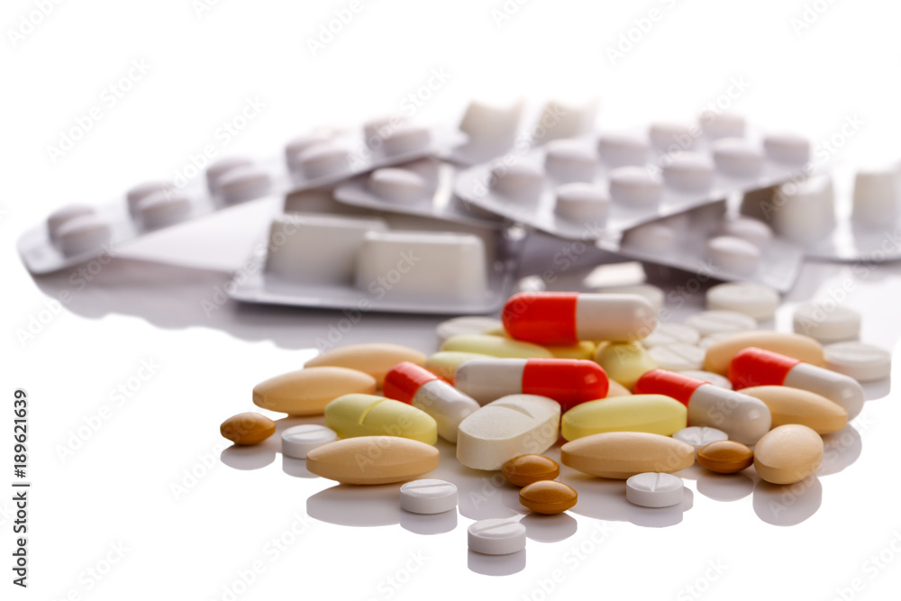Medical pills,tablets and vitamins isolated over white reflected background Medical pills,tablets and vitamins isolated over white reflected background