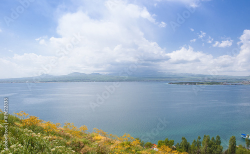 Lake Sevan in Armenia. View of the lake, the horizon and clouds. Yellow wildflowers. 