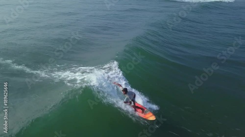 Wallpaper Mural Aerial view surfer rides blue ocean wave at sunset drone footage Torontodigital.ca