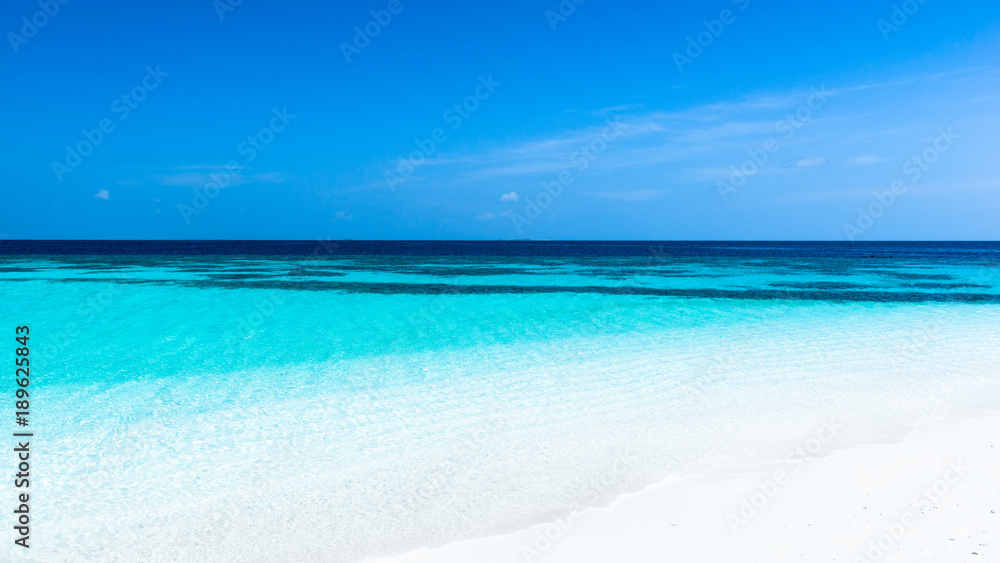Fototapeta premium Turquoise lagoon of a tropical island. Turquoise lagoon of a tropical island in the ocean. White sand on the beach. Summer paradise for relaxation.