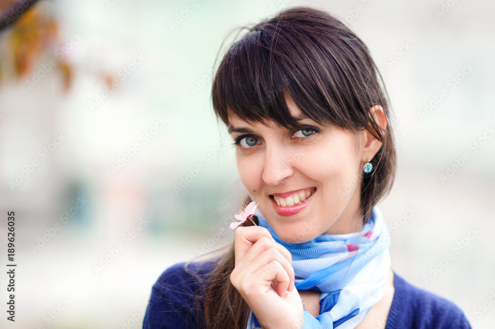 Young beautiful smiling woman face close up. Street view. Blurred background. Young beautiful smiling woman face close up. Street view. Blurred background.