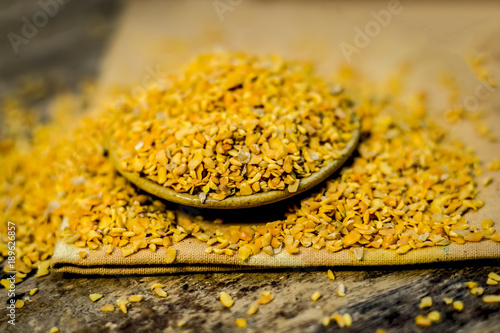 Crushed Fenugreek seeds,Trigonella foenum-graecum seeds,methi ke koriya in a bowl on wooden surface. photo