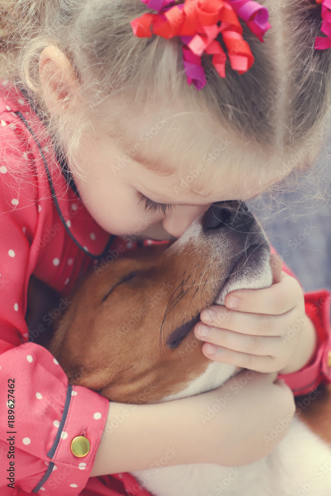 Little blonde curly girl hugging a basenji dog. Little blonde curly girl hugging a basenji dog.