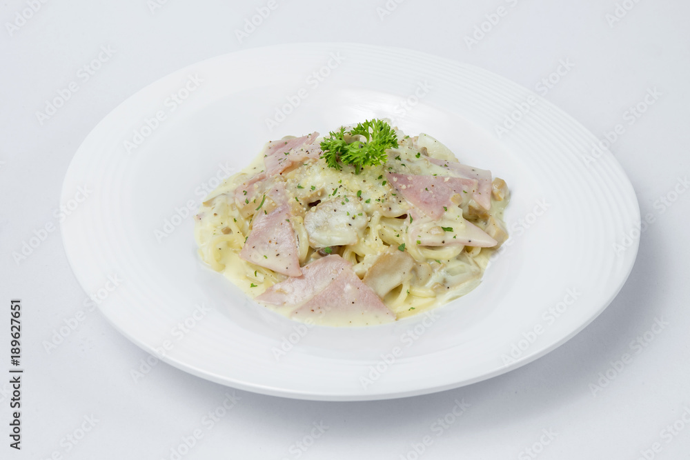 Spaghetti with ham and mushroom cream on white bowl and white Background Spaghetti with ham and mushroom cream on white bowl and white Background