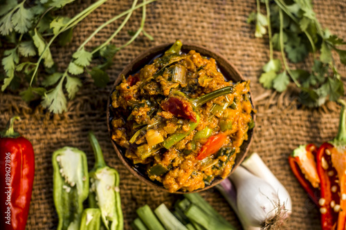 Close up of Indian Dish eaten in winter season Baingan ka Bharta with vegetables like:Spring onions,Allium fistulosum,Coriander,Coriandrum sativum,Garlic,Allium sativum and chills. photo