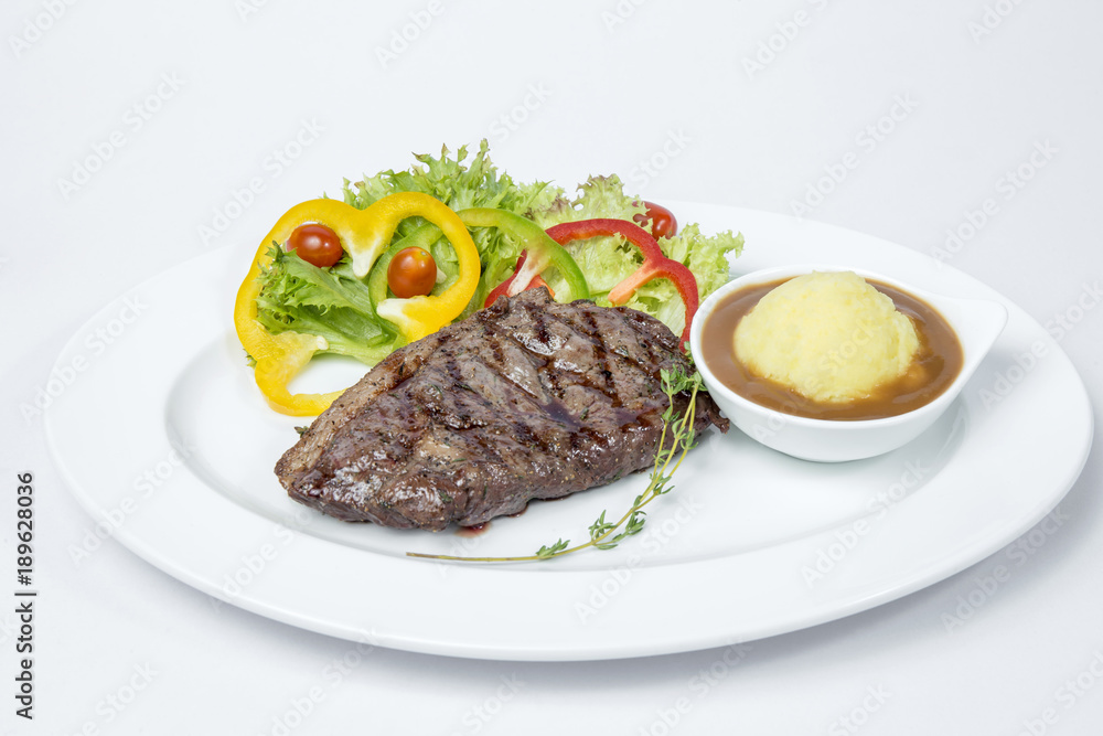 Sirloin Steak served with fresh salad and mashed potato on white background