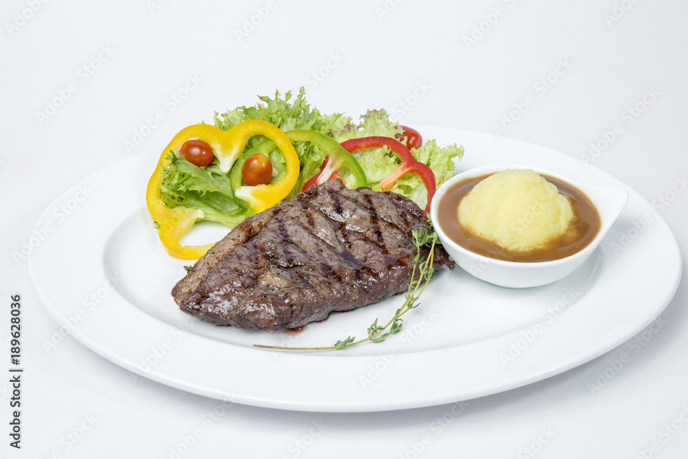 Sirloin Steak served with fresh salad and mashed potato on white background Sirloin Steak served with fresh salad and mashed potato on white background