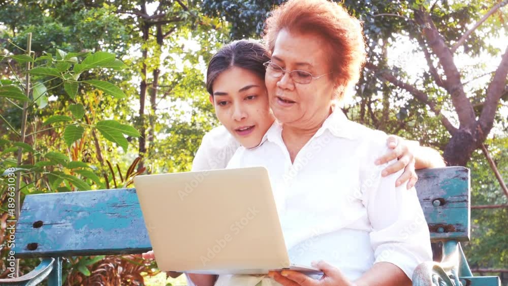 Asian woman teaching mother to use laptop. People with technology concept Asian woman teaching mother to use laptop. People with technology concept