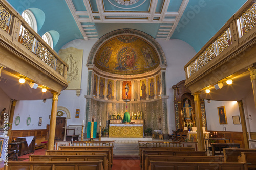 LONDON, GREAT BRITAIN - SEPTEMBER 18, 2017: The nave of church Our Lady of the Assumption with mosaic of Coronation of Virgin Mary in main apse form end of 19. cent. designed by Francis Bentley.