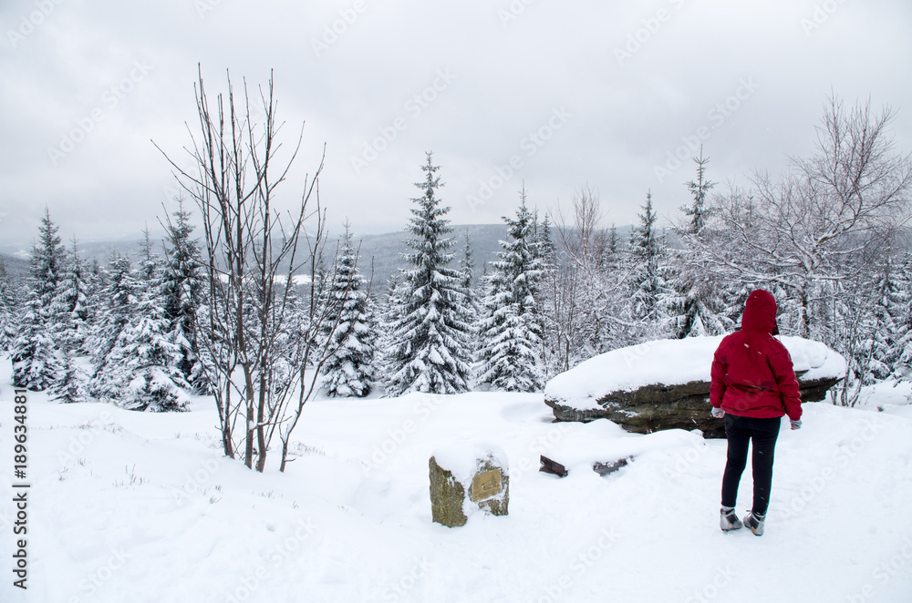 Woman taking break from cross-country skiing in Jizera Mountains.