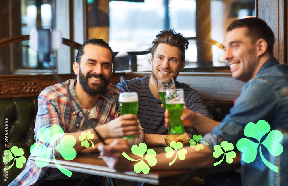 friends taking selfie with green beer at pub