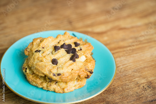 Chocolate chip cookies in blue dish on old wooden table with place for text.freshly baked.Copy space.