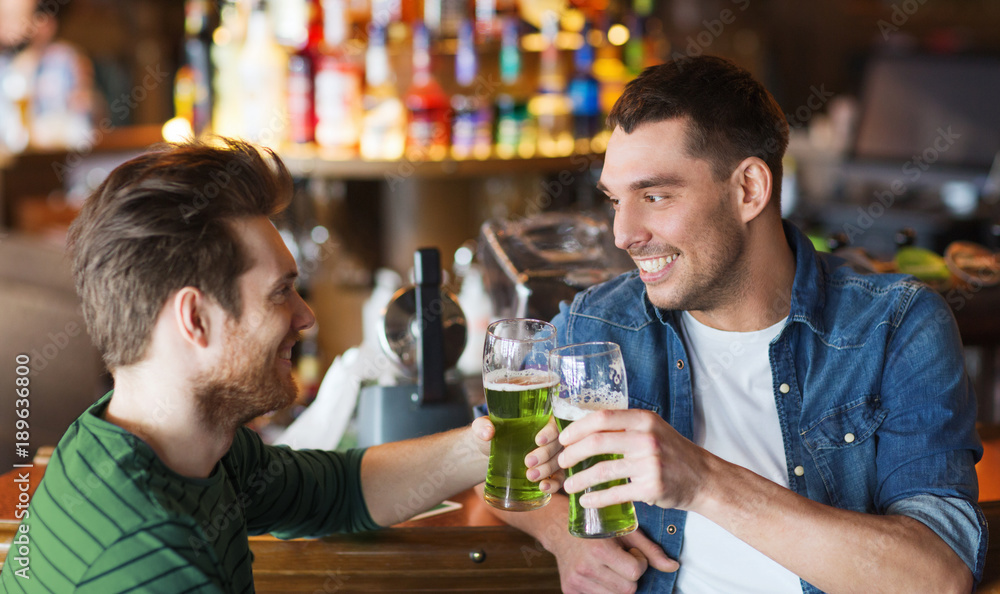 male friends drinking green beer at bar or pub