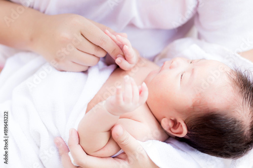 Asian newborn in mother's arm after having a bath