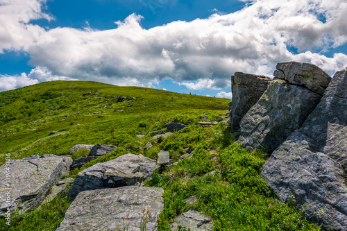 giant rocks on a hill in summertime. beautiful landscape under the blue sky with some clouds