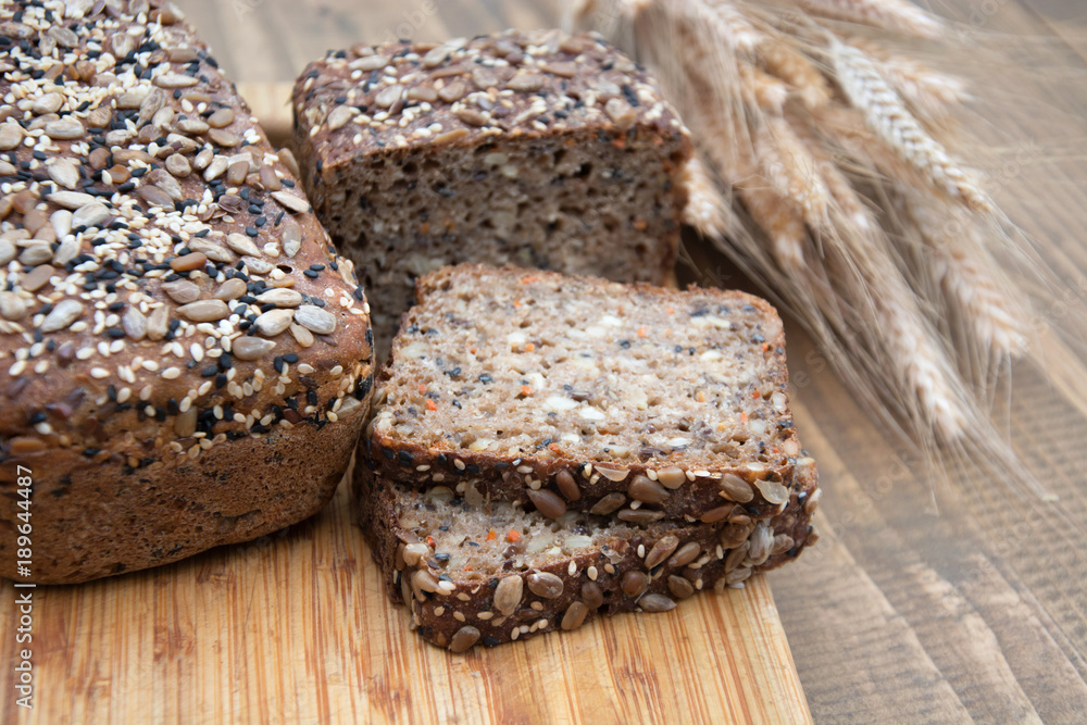 Fitness bread. A loaf of fresh rustic whole meal rye bread, sliced on a wooden board, rural food background. Close up. Fitness bread. A loaf of fresh rustic whole meal rye bread, sliced on a wooden board, rural food background. Close up.