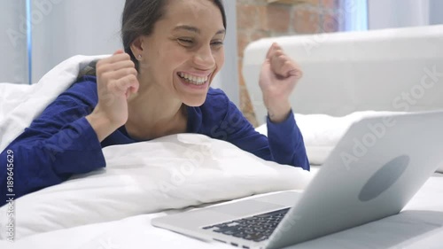 Positive Winning Hispanic Woman Celebrating Success News at Home photo