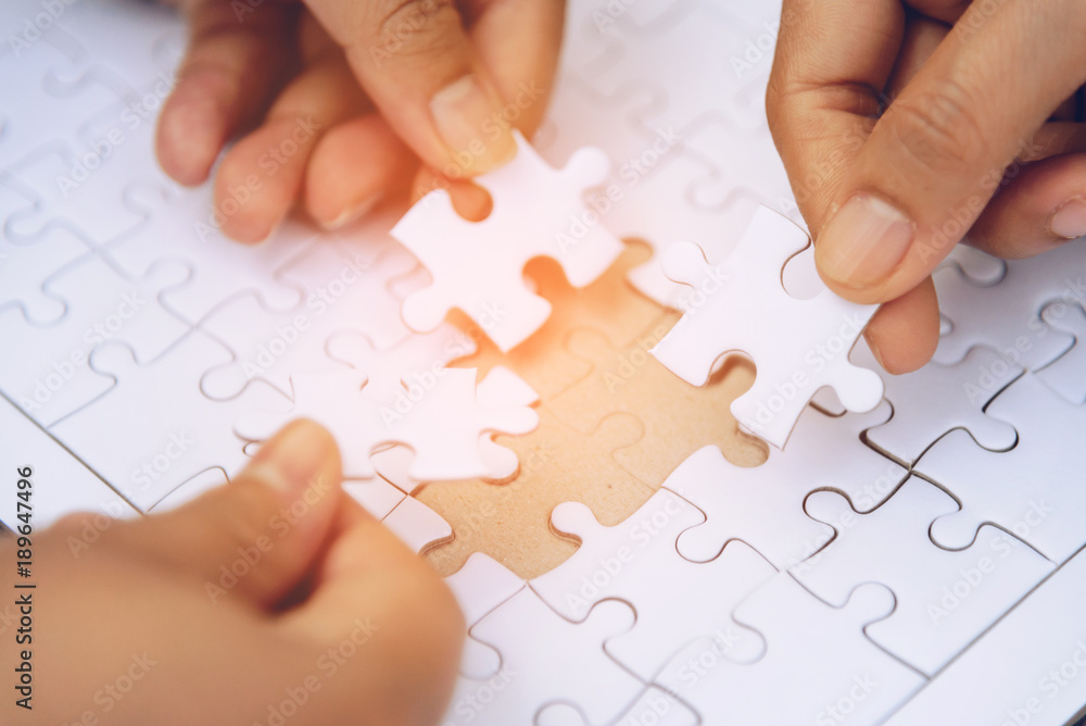 High view of a businessman jigsaw puzzles on a wooden table. High view of a businessman jigsaw puzzles on a wooden table.