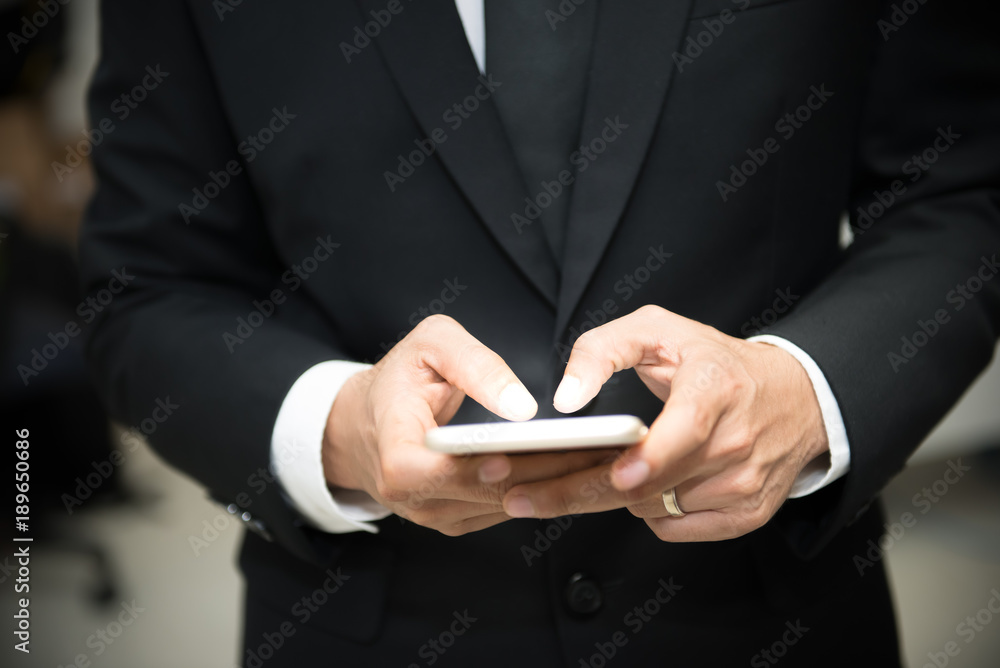 Handsome man in suit check message from mobile,smartphone for social,thailand people Handsome man in suit check message from mobile,smartphone for social,thailand people
