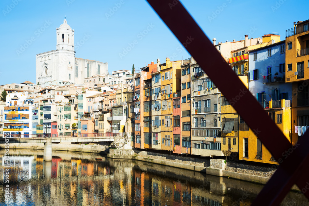 houses and church on river bank of Onyar from Eiffel bridge  in Girona
