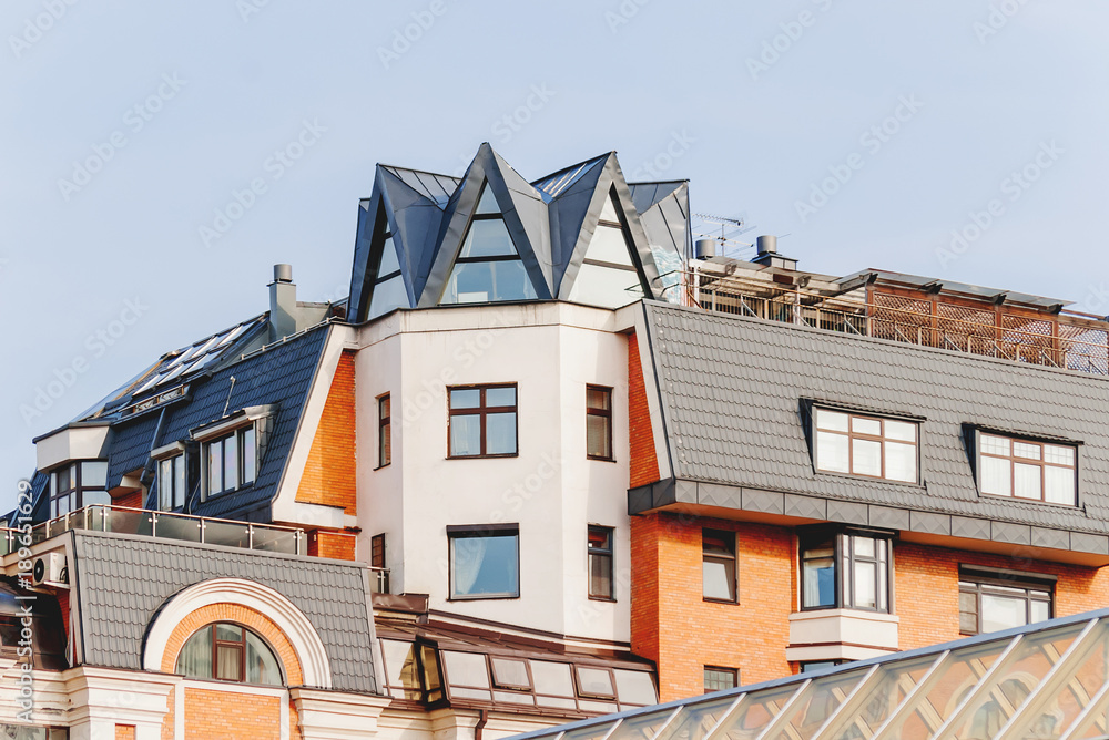 Upper floors and the attic of a house in Moscow, Russia. Interesting attic windows, gables and bay windows.