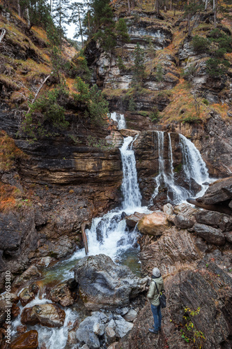 German waterfall - Kuhfluchtwasserfall - near the german alps while autumn. Woman standing in front of the waterfall. photo