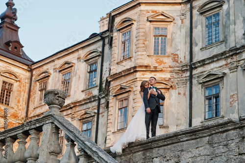 Fabulous wedding couple walking around the castle territory on their festive day. © AS Photo Family