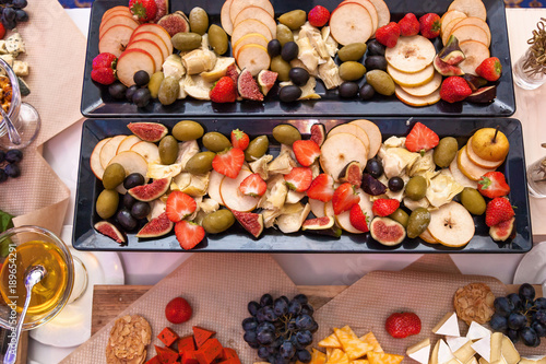 Fototapeta Naklejka Na Ścianę i Meble -  Sliced fruit figs strawberries pears olives strawberries.