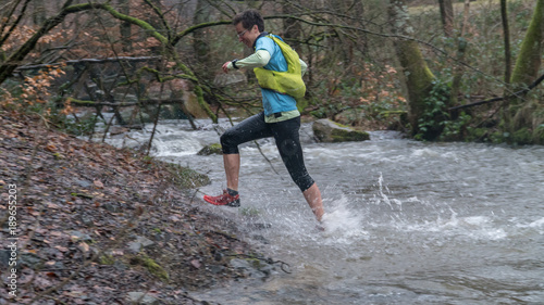 Woman running through a streambed.