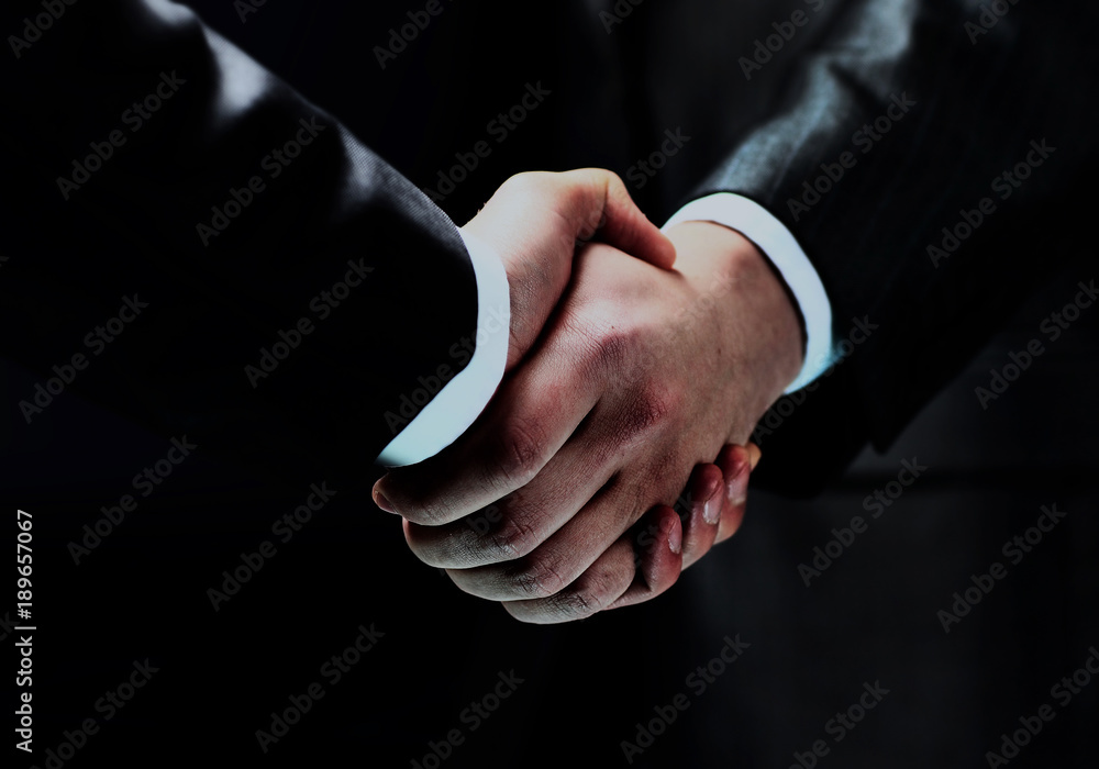 Handshake - Hand holding on black background. Handshake - Hand holding on black background.